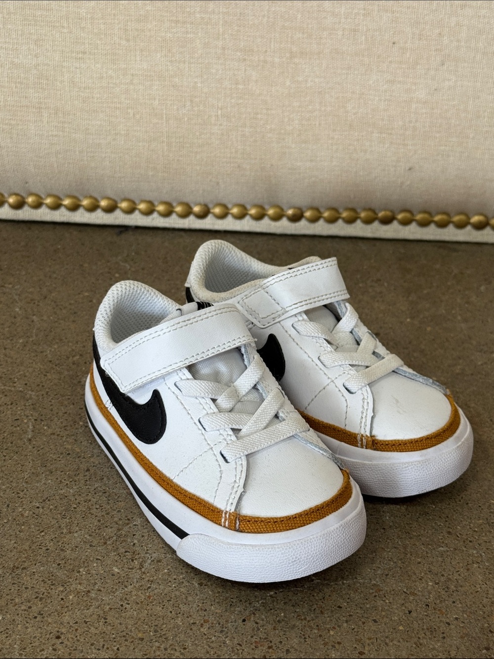 Nike Kids White Sneakers with Black Swoosh and Gold Accent